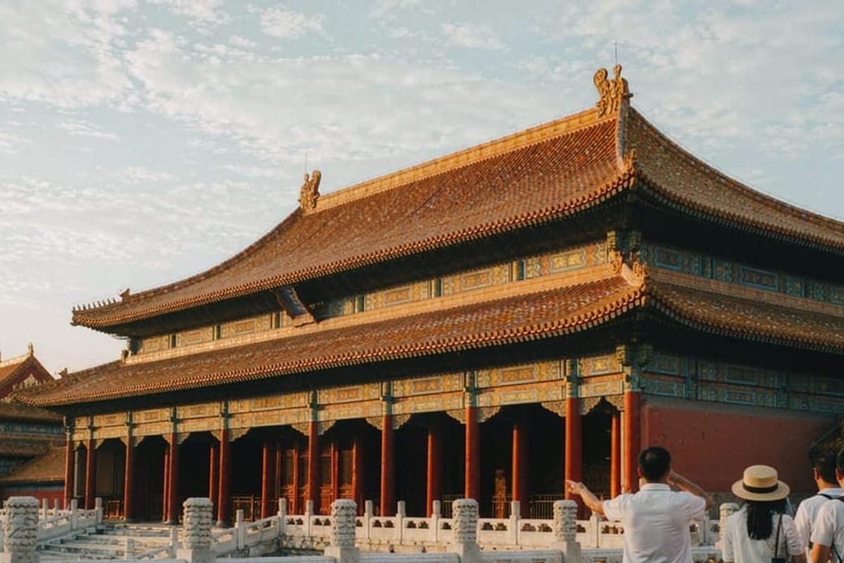 Viajantes com guia no pátio de um palácio chinês